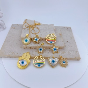 Detailed macro view of assorted gold-plated evil eye charms with white shell on stone base