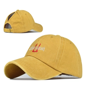 Detail of ginger cotton ponytail baseball cap with red Übermensch embroidery and metal buckle