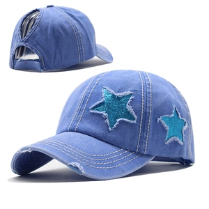 Détail d'une casquette queue de cheval bleu clair avec patch étoile et bords effilochés