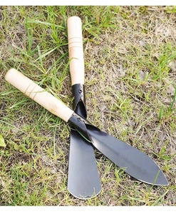 Outdoor garden tool set with pointed and flat shovels on grass, featuring wooden handles
