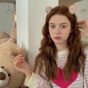 Detail of cute pink plush bear ear hair clips worn by a model in casual attire