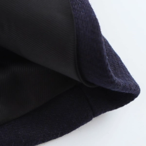 Macro detail of navy blue wool fabric and smooth black satin lining on the coat
