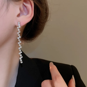 Close-up of silver tassel earrings with zircons on model for a luxury jewelry look