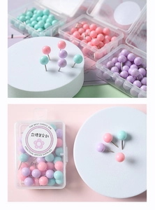 Détail de punaises à tête ronde perle macaron dans une boîte de rangement en plastique