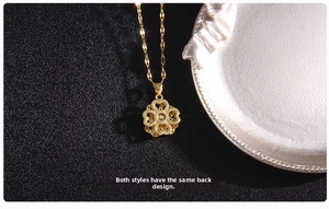 Detailed close-up of gold clover pendant with intricate heart cutout on dark textured base