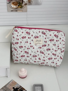 Detailed macro of floral corduroy makeup bag with quilted texture and red zipper