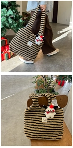 Detail of plush black and yellow striped tote bag with a cute white dog charm
