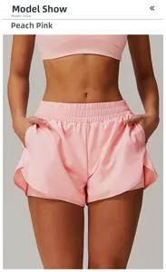Détail du short de fitness rose pêche à taille haute avec poches et design superposé