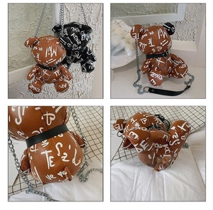 Detail view of graffiti bear crossbody bags with silver metal chains in black and brown