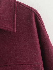 Detail of wine red wool coat collar showing premium stitching and fabric texture