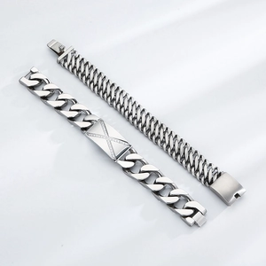 Détail de bracelets gourmettes en acier argenté avec une breloque en X sertie de CZ brillant