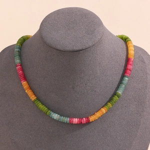 Close-up of a colorful tourmaline gemstone beaded necklace on a grey display bust