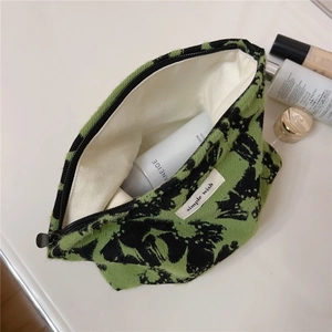Detail of green floral makeup bag featuring ivory canvas lining and large capacity storage