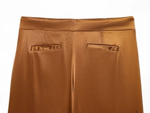 Detailed view of brown satin high-waisted wide-leg trousers with pocket and rear waist seam