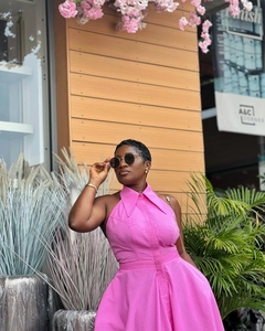 Detail of vibrant pink sleeveless maxi dress with halter collar and button-down front