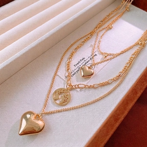 Three-layer gold layered heart necklace with world map pendant on jewelry box