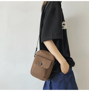Brown canvas crossbody bag for men and women with adjustable strap and front snap pocket