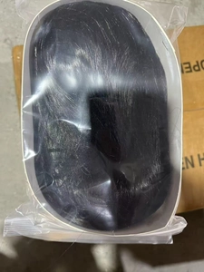 Detail view of long wavy black synthetic wig in protective plastic sealing bag