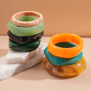 Detailed view of irregular resin bangles with colorful marble and amber textures