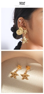 Detail view of golden starfish and conch earrings with intricate metallic textures