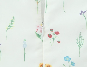 Makroaufnahme eines versteckten Reißverschlusses am weißen Blumenkleid mit Spitzenbesatz