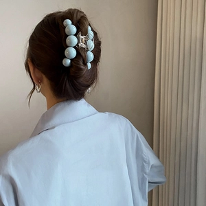 Pince à cheveux boules bleu clair portée sur une coiffure élégante de modèle