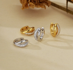 Detail of S925 sterling silver hoop earrings with white zircon in gold and silver tones