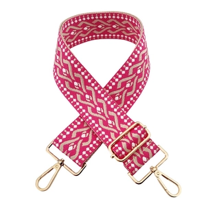 Detail of pink and beige geometric woven wide shoulder strap with gold metal hooks