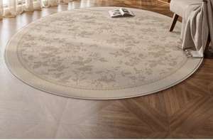 Detail of round vintage rug with floral patterns on a wooden herringbone floor