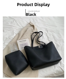 Detail of black pebbled leather tote bag and pouch set on white fabric background