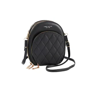 Close-up of black quilted PU leather crossbody bag featuring three golden zipper layers