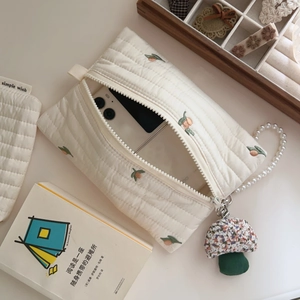 Detailed view of quilted cotton mobile phone bag with orange fruit embroidery and pearl chain