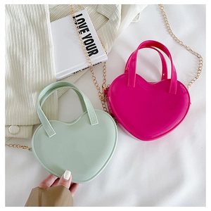 Detail of heart-shaped mini jelly bags in mint and rose pink with gold chain straps
