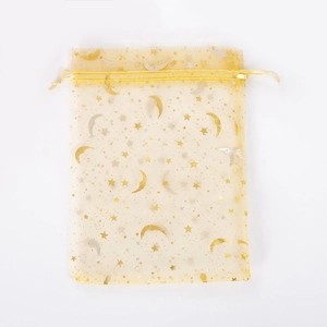 Close-up of yellow organza drawstring pouch with gold and silver moon star patterns
