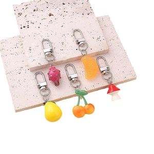 Colorful resin fruit keychains featuring dragon fruit, orange, pear, cherry and mushroom