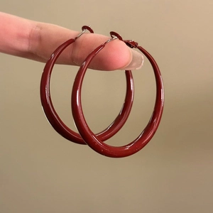 Classic large red hoop earrings with smooth glossy finish in minimalist geometric style