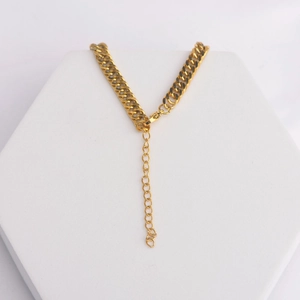 Vintage 18K gold plated Cuban link necklace with lobster clasp on a white pedestal