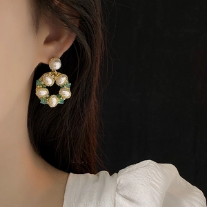 Primo piano della modella che indossa orecchini a cerchio dorati con perle e cristalli