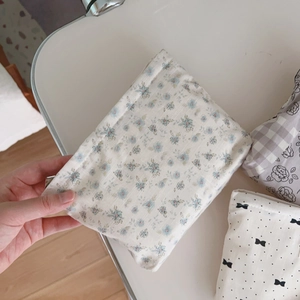 Detail of assorted floral and polka dot fabric pouches with bow and zipper closure