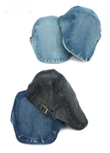 Stack of vintage washed denim beret hats showing metal side buckles and texture detail