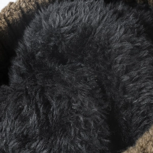 Macro shot of the thick black fleece lining in a warm winter knitted beanie hat.