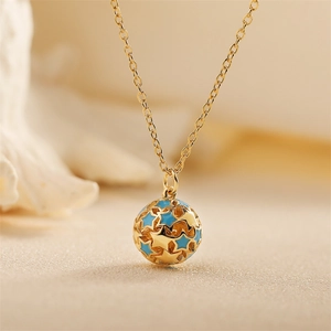 Gold hollow ball pendant necklace with blue enamel stars on a delicate link chain
