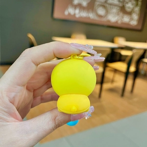 Back view of a cute yellow cartoon puppy keychain with a round tail and smooth texture