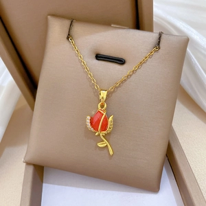 Luxurious titanium steel necklace with red rose pendant and small diamonds on a display