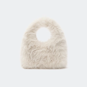 Gros plan du sac pelucheux blanc crème en fausse fourrure avec poignée ronde intégrée