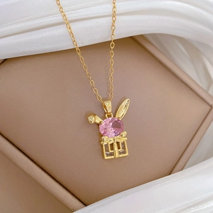 Close-up of gold rabbit gift box pendant with pink and clear crystals in a display box