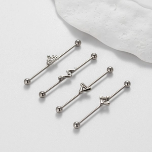 Detailansicht der 1,2mm Industrial-Barbells mit Kronen-, Schlangen- und Dreiecksmotiven