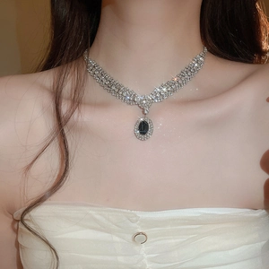 Close-up of a silver rhinestone choker necklace with a vintage black oval gemstone pendant