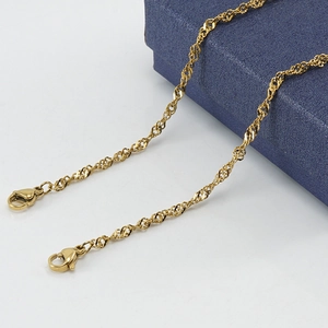 Macro shot of gold 18K plated stainless steel water wave chain with secure lobster clasp