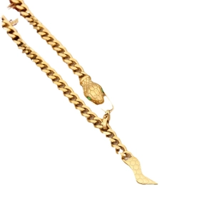 Golden snake-shaped necklace with green gemstone eyes and hexagonal scale texture